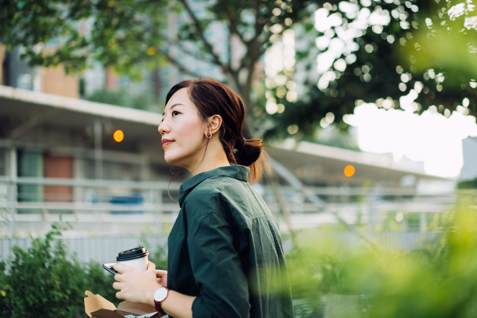 Woman holding a coffee in a natural environment