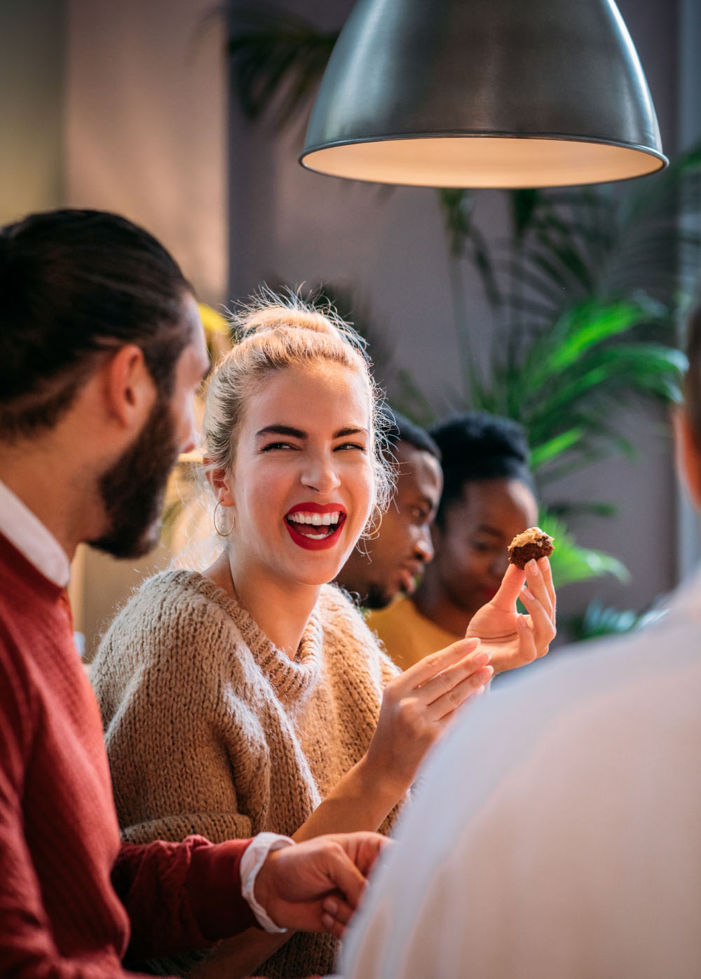 Woman laughing while eating in a restaurant